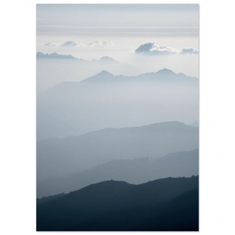 Layered mountain ranges in atmospheric perspective, with forested foreground darkening to misty peaks and clouds in the distance.